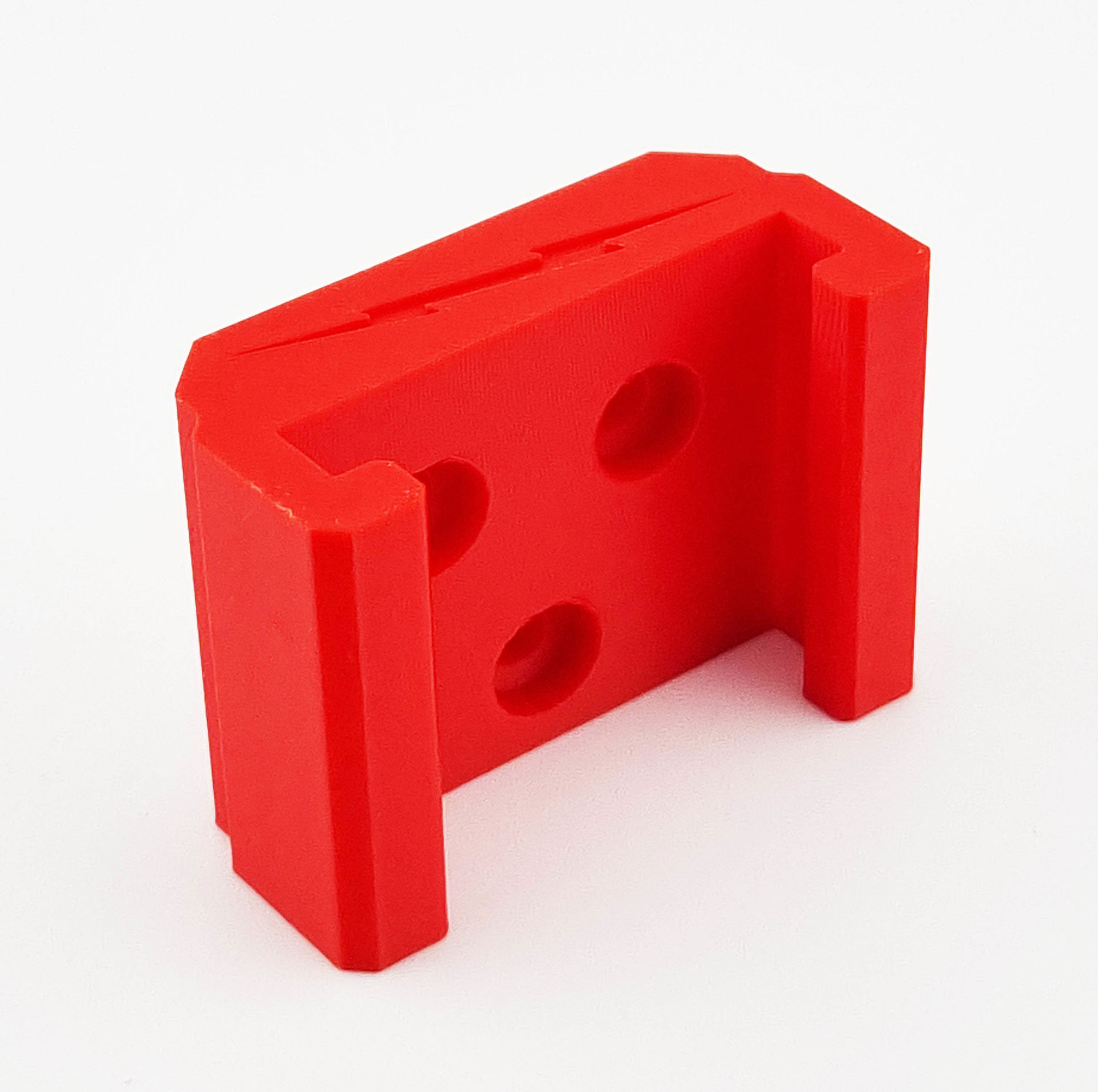 Rød Milwaukee 18V batteriholder med tre monteringshuller og skinner.