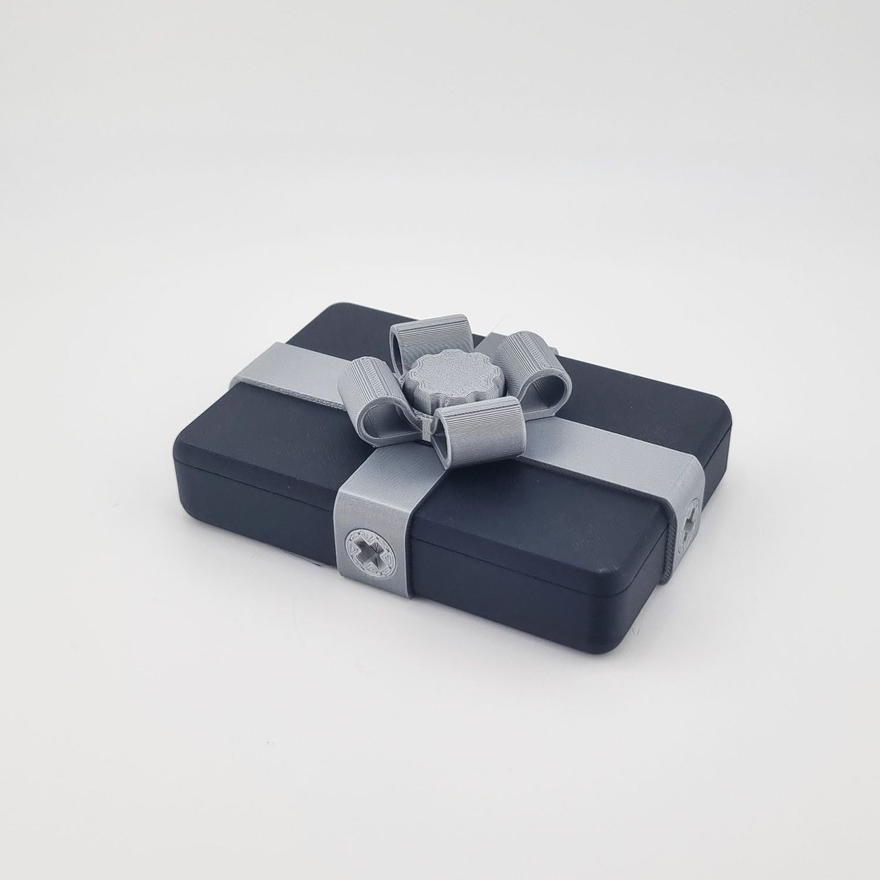 Sort drillegaveæske version 2 med sølvfarvet bånd og sløjfe.