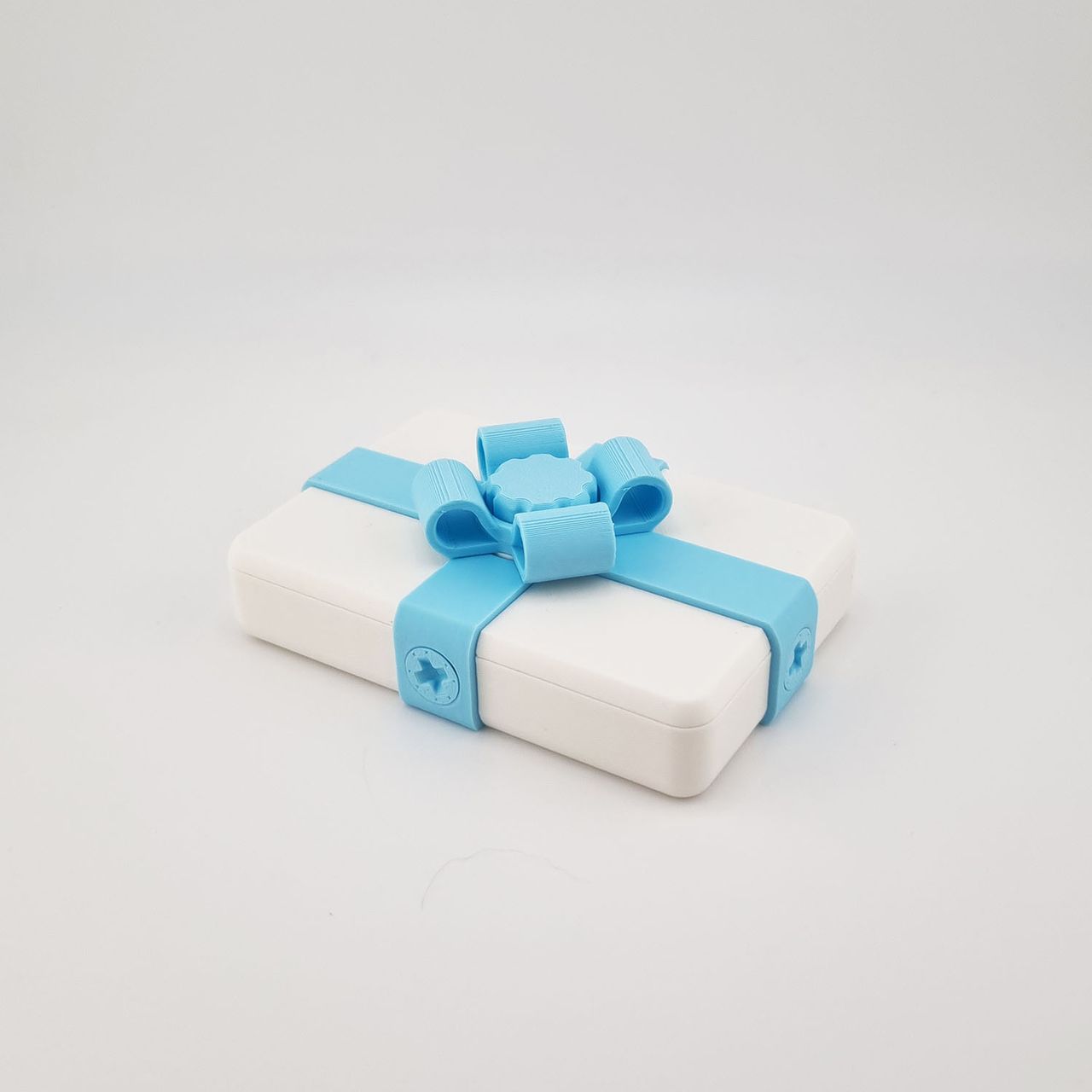 Hvid 3D-printet gaveæske med lyseblåt bånd og sløjfe.