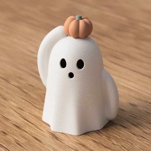 Hvid spøgelsesfigur med sorte ansigtshuller og orange græskar på hovedet.