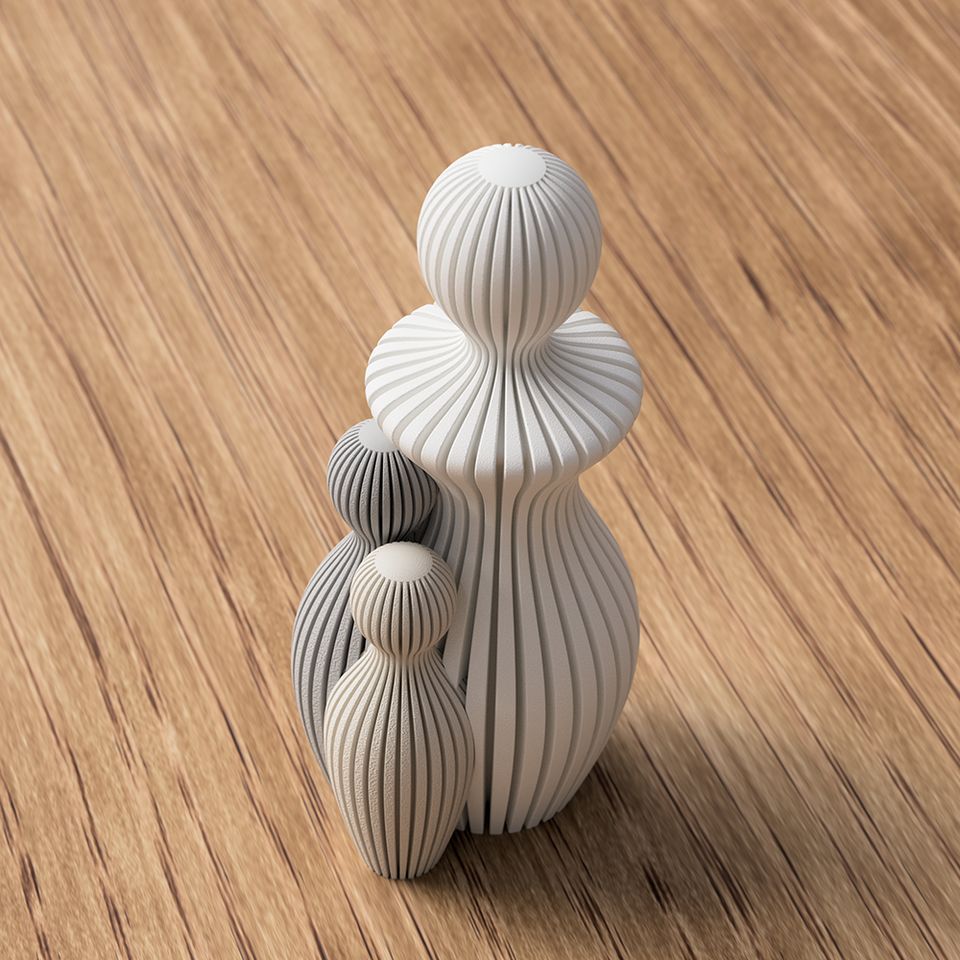 3D-printet familiefigurer i beige og grå med lodrette riller.