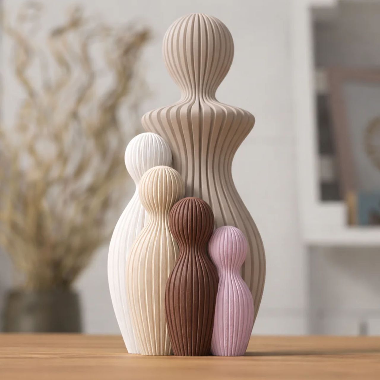 Fem riflede familiefigurer i beige, hvid, brun og lyserød.