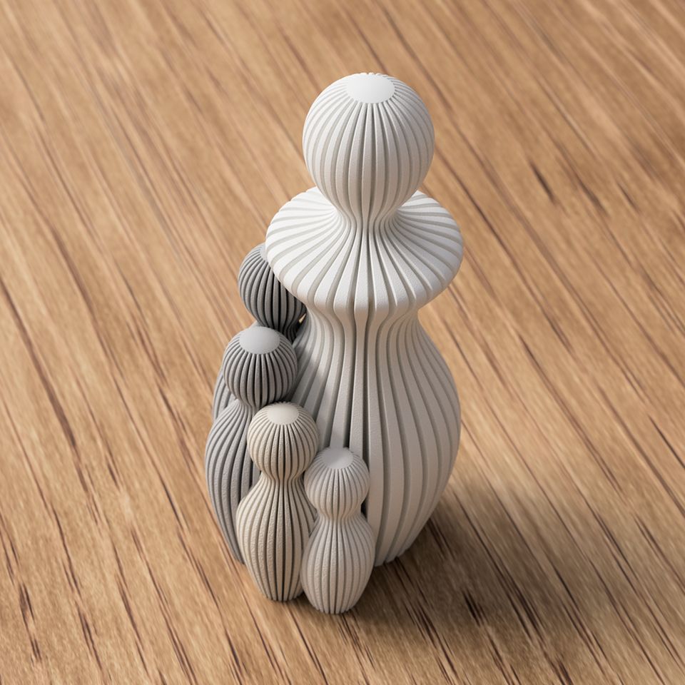Grå 3D-printet familiefigur med fem stiliserede, lodret riflede personer.