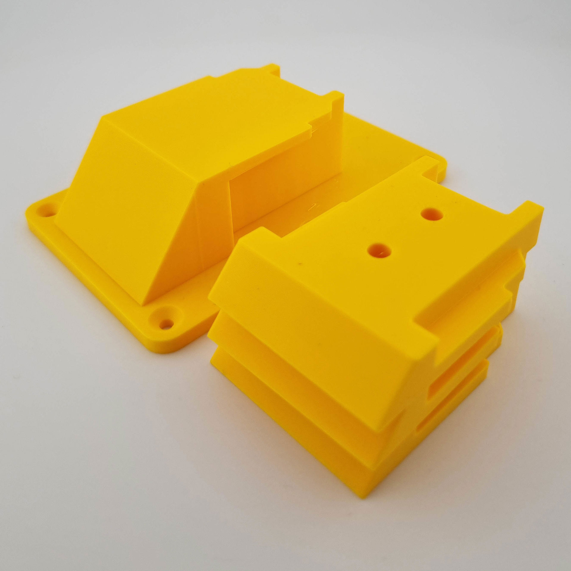 Gul DeWalt 18V/20V værktøjsholder med monteringshuller og stabelbare dele.